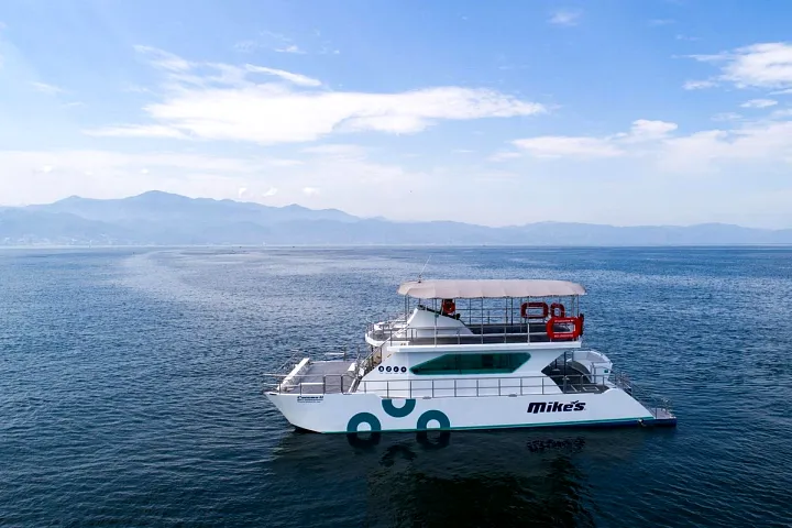 Catamaran 72 at sea with mountains in the distance